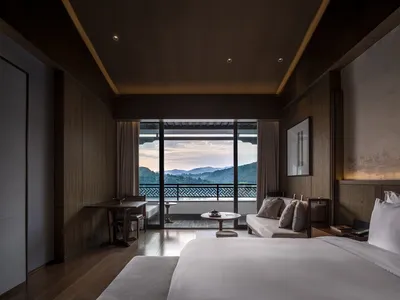 Modern hotel room featuring wooden furniture and a scenic view.