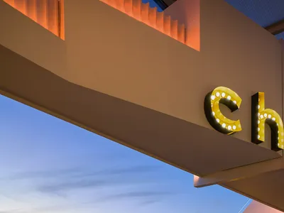 A modern hotel viewing platform featuring illuminated seating and a panoramic cityscape view.