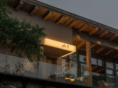 Modern restaurant exterior with wooden structures and warm lighting