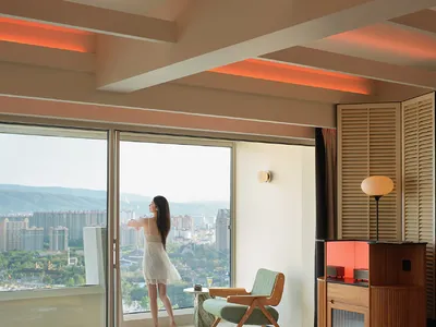 A modern hotel suite featuring metallic furniture and glass panels.