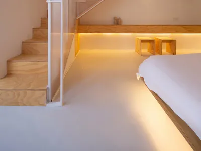 Modern residential bedroom featuring minimalist design with wooden flooring and glass windows.