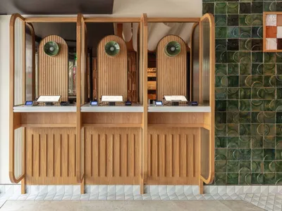 A modern restaurant interior with a wooden counter and digital signage.