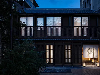 A traditional Japanese restaurant at night with wooden design elements and a welcoming entrance.