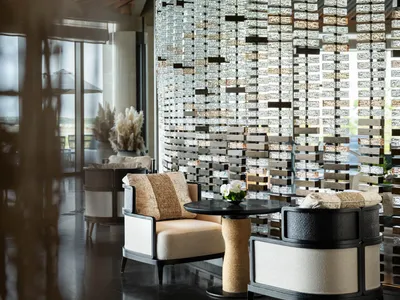 A luxurious hotel lobby featuring modern seating and a decorative glass brick partition