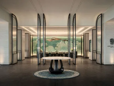 A modern hotel lobby featuring marble, glass, and metal materials
