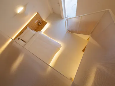 A modern minimalist bedroom with white wooden furniture and a minimalist design aesthetic.