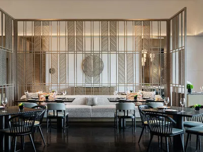 A modern restaurant interior with metallic, glass, and wooden elements.