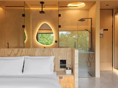Minimalist bedroom with a bed, marble floor, and wooden accents.