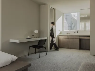 A modern hotel room with a concrete floor and minimalist design.