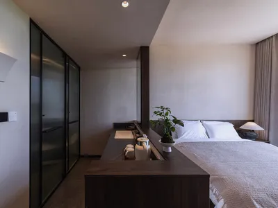 一間現代臥室，配有木質家具與極簡設計。