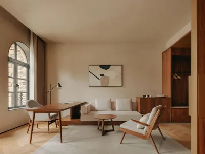 Minimalist living room with beige furniture and wooden floor.