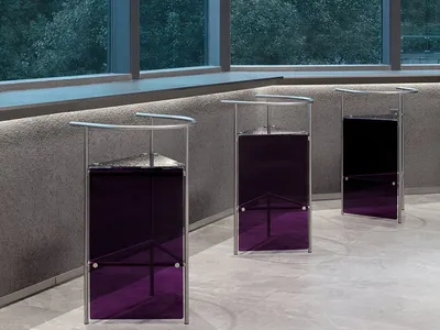 Modern hotel lobby with glass and metal furniture and black curtains.