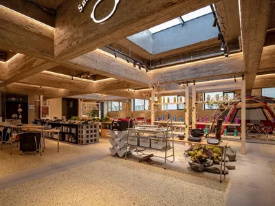 Modern industrial-style restaurant interior with concrete finishes and exposed concrete ceiling beams
