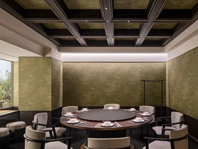 A modern restaurant interior with a dark wall color, wooden dining table, and glass windows.
