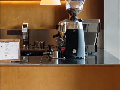 Modern coffee shop with a coffee roaster mounted on a wooden wall.