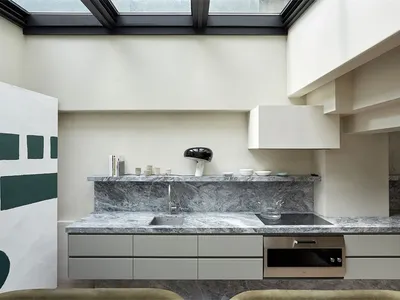 Modern kitchen with marble countertops and grey stone backsplash