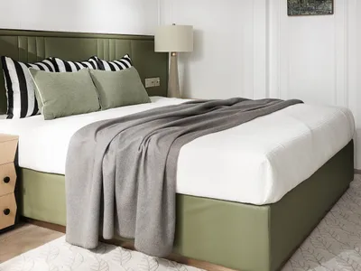 A minimalist bedroom with a green leather headboard, grey quilt, and white bedding, decorated with a black and white striped