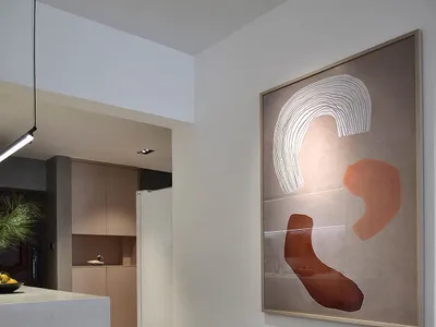 A modern minimalist kitchen with concrete finishes and abstract art.