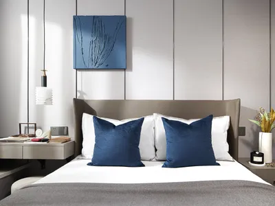 A modern classic bedroom featuring a bed with white and gray textiles, a wooden headboard, and a metal nightstand.