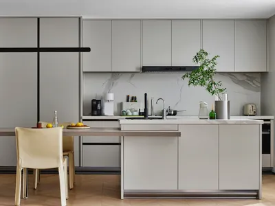 A modern kitchen with a marble countertop and matte-finished cabinets.
