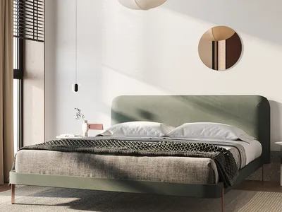 A modern minimalist bedroom featuring a fabric-covered bed in a light green color, with a geometric pendant light and a circu