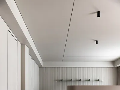 Modern minimalist bedroom with wooden floors, marble divider, and glass wall, featuring a comfortable bed with elegant beddin