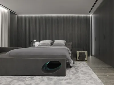 Modern minimalist bedroom with grey walls, wooden floors, and a grey bedspread.