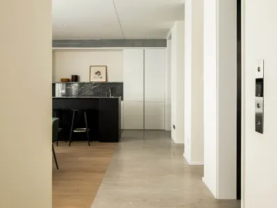 A modern interior space featuring a sleek concrete floor and a striking marble kitchen counter.