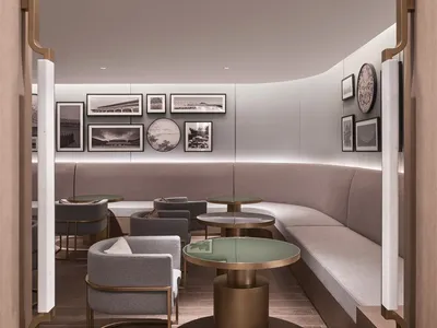 A modern restaurant-cafe with neutral textiles, bronze tables, and glass-top tables.