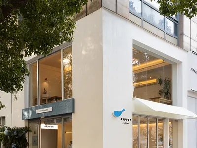 Modern coffee shop exterior with glass walls and concrete finish