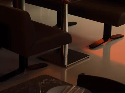 A warm and inviting dining area with an orange table surrounded by chairs, wine glasses, and a cozy atmosphere