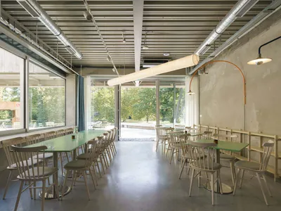 A bright and inviting restaurant interior with multiple dining tables and chairs, modern design, and ample seating options