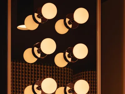 A well-lit bathroom with a large mirror surrounded by multiple lights, creating a bright and inviting atmosphere