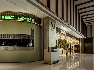 Modern Asian restaurant with green walls, a large sign, and potted plants inside