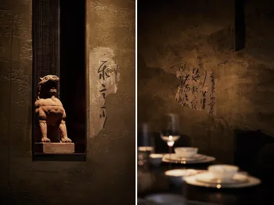 A restaurant and temple scene with wine glasses, cups, and a lion statue, set against a cultural backdrop