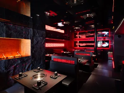 Modern restaurant dining area with multiple TV screens, tables, and chairs, creating a comfortable and inviting atmosphere