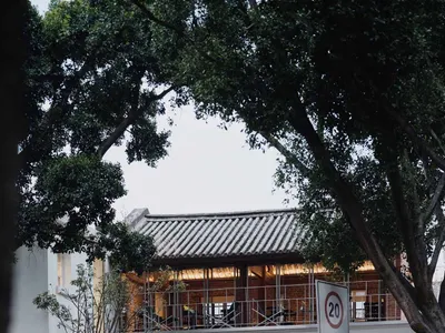 Modern Asian restaurant with a boat-shaped roof, wood and metal elements, and a spacious dining area with tables and chairs
