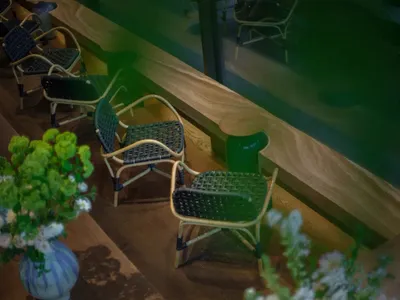 A room with multiple wooden chairs in various positions, creating a warm and inviting atmosphere for relaxation and socializing