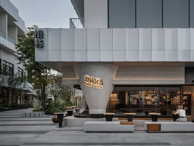 A modern Asian restaurant with a large dining area featuring several tables and chairs, with inviting and comfortable atmosphere