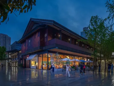 Modern Asian restaurant with a large dining area, wooden flooring, metal accents, and umbrellas providing shade to tables