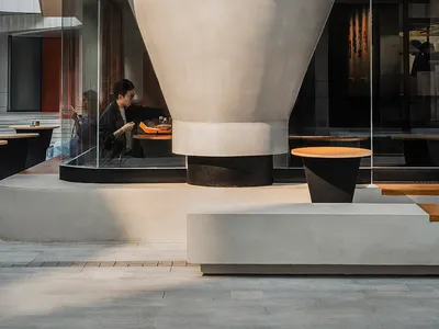 A lively modern Asian restaurant with a large white dome structure, tables, and people enjoying meals
