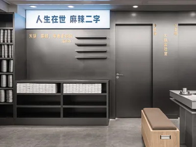 亞洲風格衛浴間，兩扇開啟的門、一座洗手台、一張長椅，以及一座擺放數本書的書櫃，傳達乾淨整潔的氛圍，強調功能性與簡約