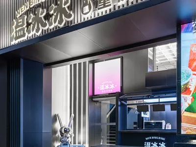 A modern Asian restaurant with a black countertop, natural light, and TV screens on the walls