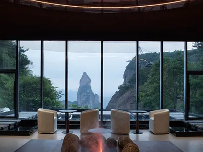 Comfortable dining space with a large window offering a mountain view, featuring chairs, a dining table, and couches