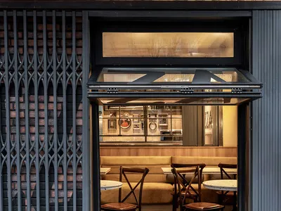 A casual dining area with white tables and varied chairs, set in a restaurant with a cozy atmosphere