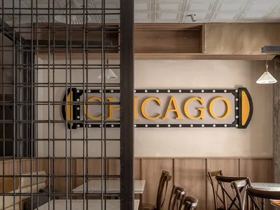 Cozy restaurant dining space with wooden walls, multiple tables, and chairs, featuring a warm and inviting atmosphere