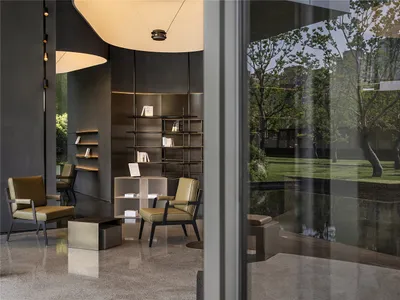 Cozy living space with a large bookshelf, two chairs, and a dining table, creating a warm and inviting atmosphere