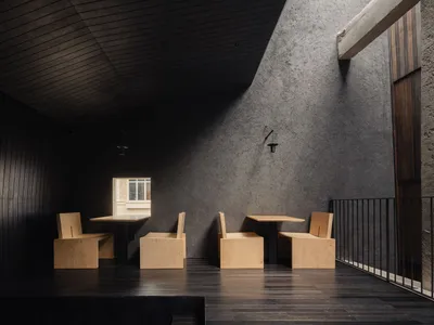 Cozy modern living and dining space with grey walls, wooden floors, and a dining table surrounded by chairs
