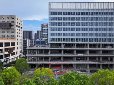 現代飯店建築新建中的外觀照片，擁有大型玻璃立面與停放的車輛
