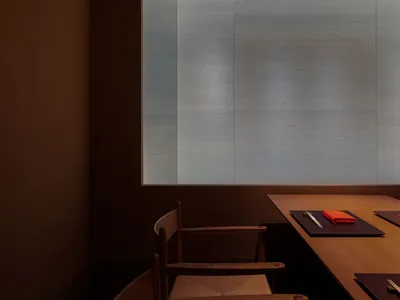 Dimly lit room with a glass wall, two chairs, a dining table, and a book, in a modern and minimalist style